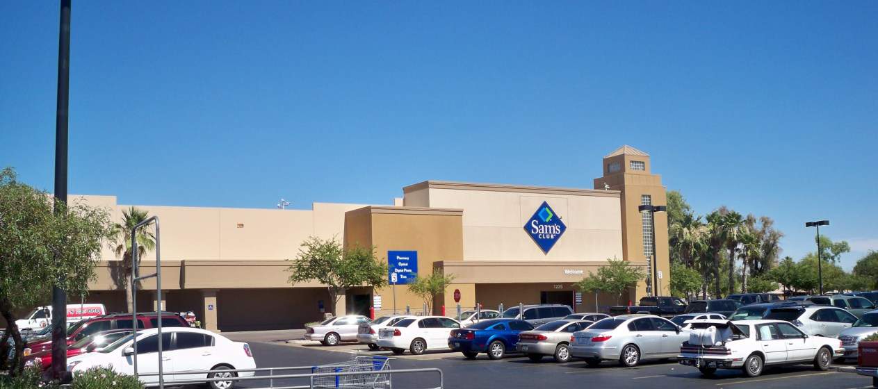 Multiple locations of Sam's Club have parking lots with cars parked in front of the store.