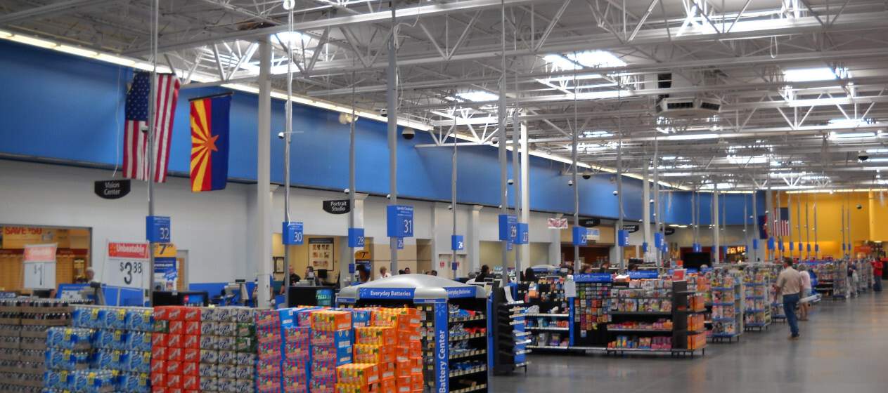 A vibrant Walmart store, showcasing blue walls adorned with American flags.