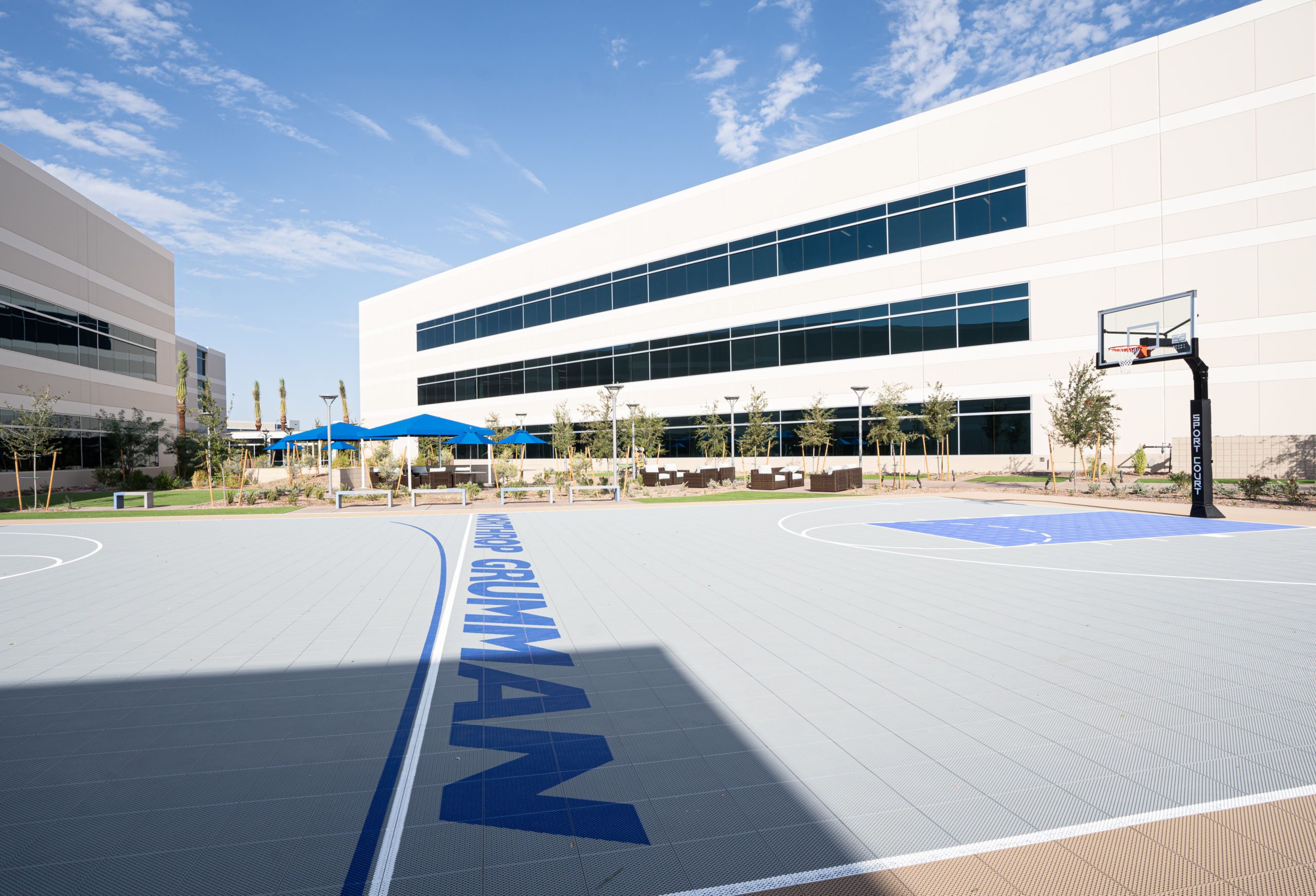 A basketball court in front of an Office Building, featuring the Office Build to Suit Project of the Year.