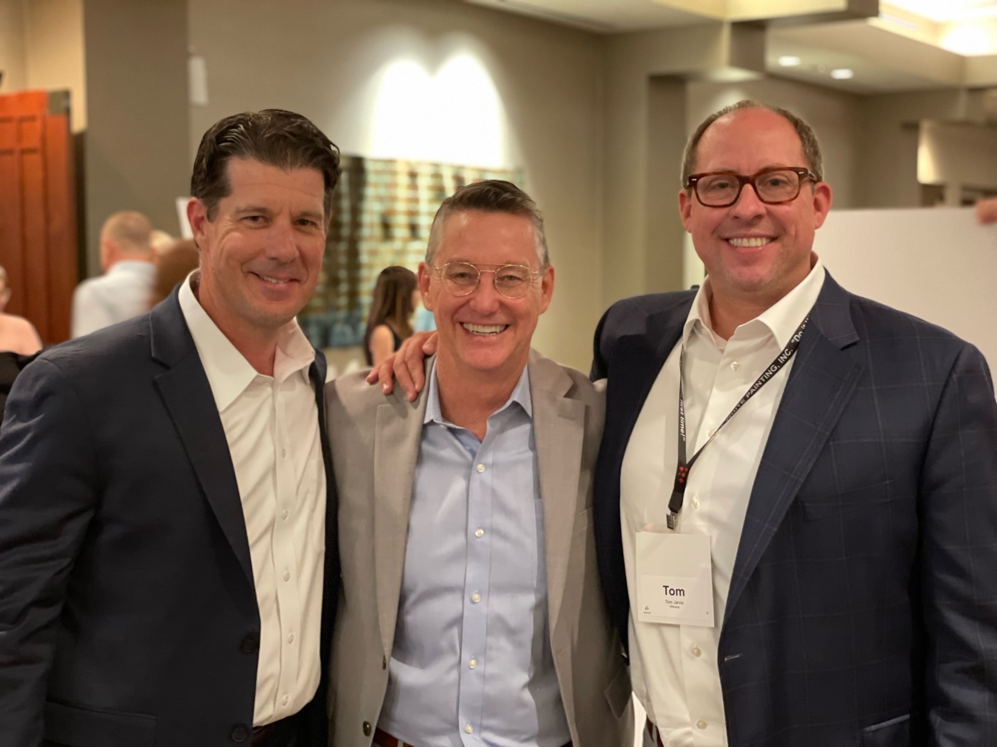 Three men in business suits posing for a photo at the Best of NAIOP 2022 event.