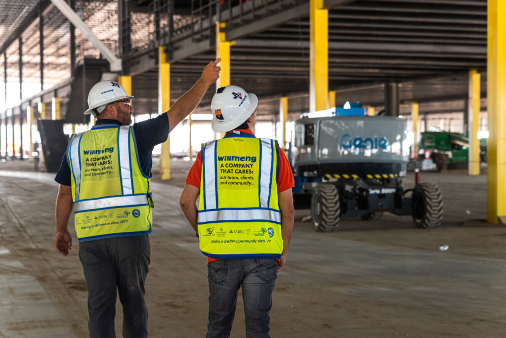 Two men in safety vests standing in a warehouse during ASC Recruiting Event 2.