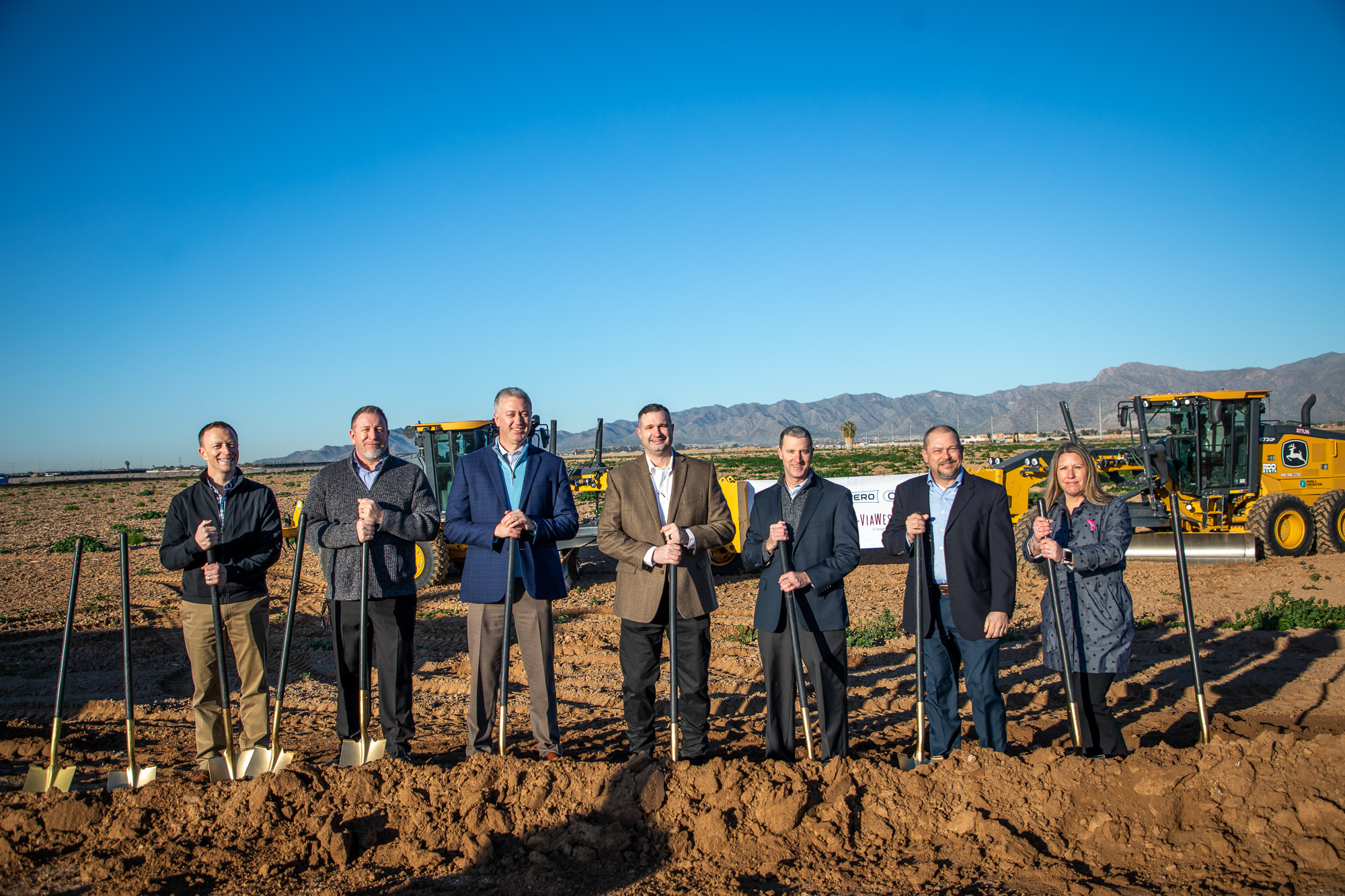 ViaWest and Willmeng Construction break ground on an industrial project in front of a dirt field.