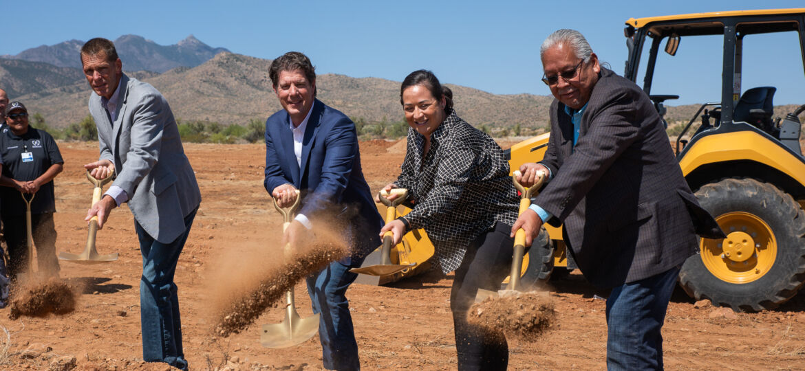 A group of people with shovels in front of a bulldozer, working to establish a Health Center for the San Carlos Apache Community.
