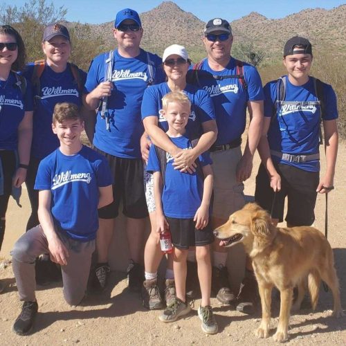 Willmeng participates in 16th annual Run for Ryan House alongside a group of people in blue shirts, posing with a dog.