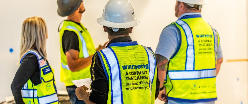 A group of construction workers from Willmeng Construction standing in a room.