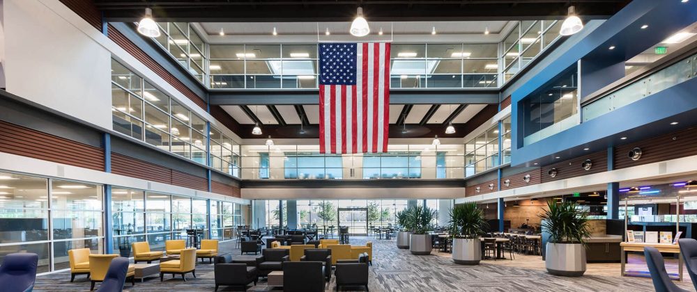 The lobby of a building with an american flag hanging from the ceiling.