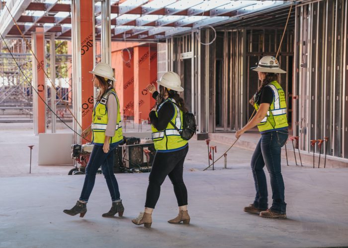 Three women construction workers walking through a building.